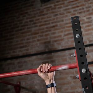 A person's hands gripping a pull-up bar.